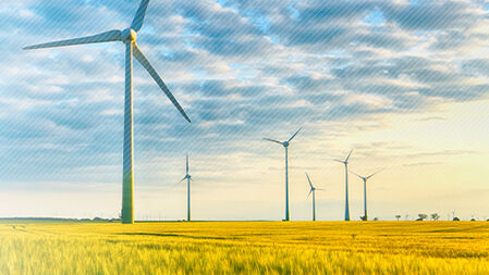 Foto mit Windrädern auf Feld und Wolken