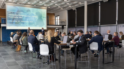 Konferenzraum des Fraunhofer IWU mit Bühne, Sprecher und Teilnehmern